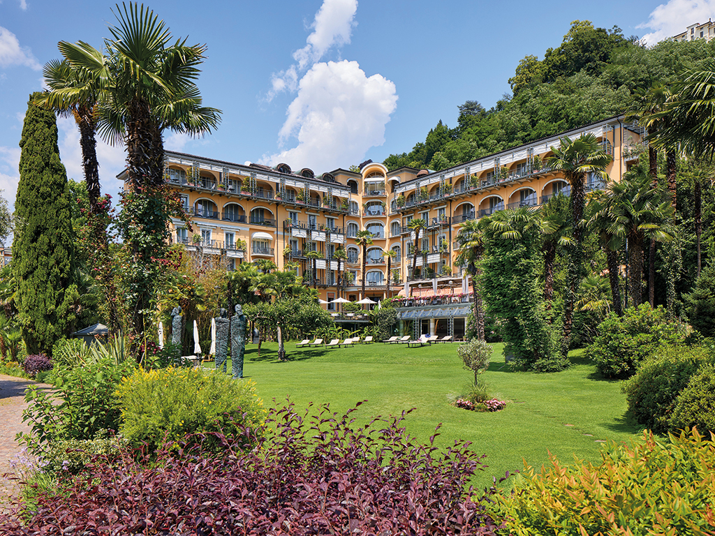 A large villa surrounded by a beautifully landscaped garden and plants